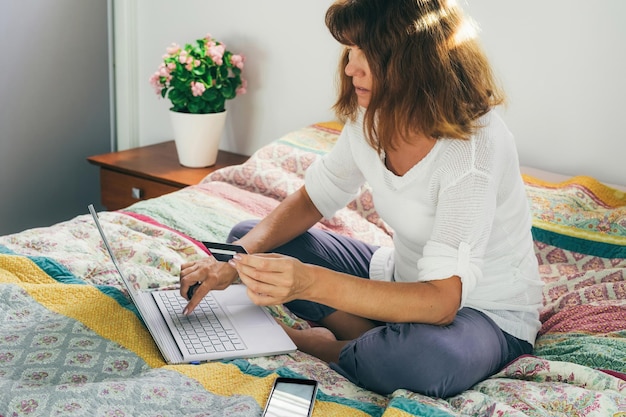 Foto mujer usando una computadora portátil en casa