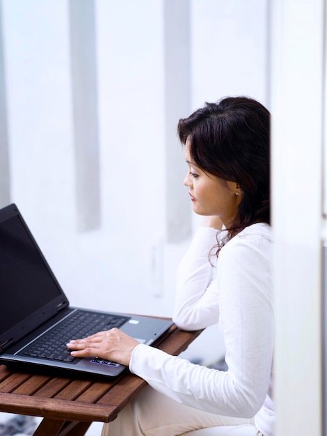 Mujer usando una computadora portátil en casa