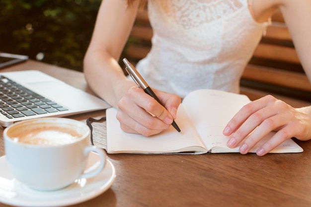 Mujer usando una computadora portátil durante un descanso para tomar café