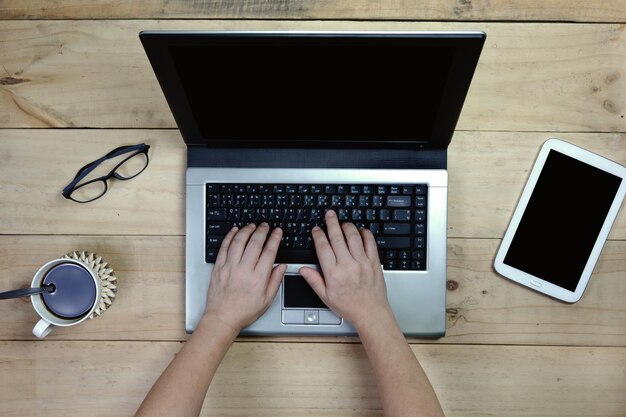 mujer usando computadora portátil con equipos de oficina