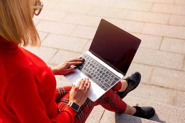 Mujer usando una computadora portátil mientras está sentada afuera