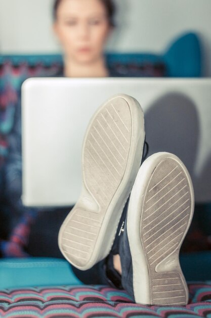 Mujer usando una computadora portátil mientras está sentada en casa
