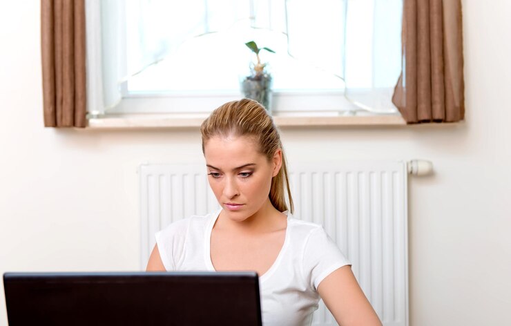 Foto mujer usando una computadora portátil mientras está sentada en casa