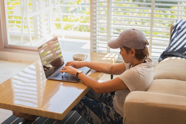 Mujer usando una computadora portátil mientras está sentada en el piso en la sala de estar