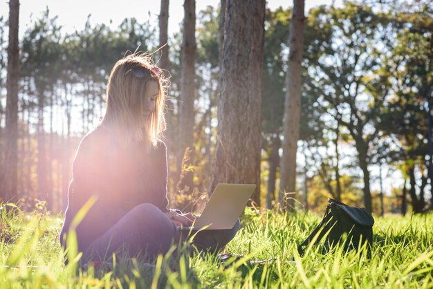 Mujer usando una computadora portátil en el parque