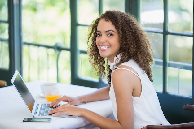 Mujer usando una computadora portátil en un restaurante