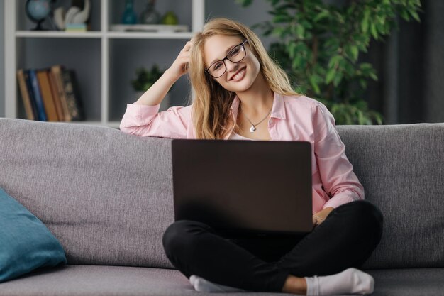Mujer usando una computadora portátil en el sofá