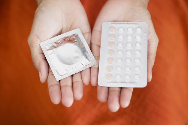 Foto la mujer está usando condones y píldoras anticonceptivas. antes de tener relaciones sexuales con su novio cada vez para prevenir el embarazo.