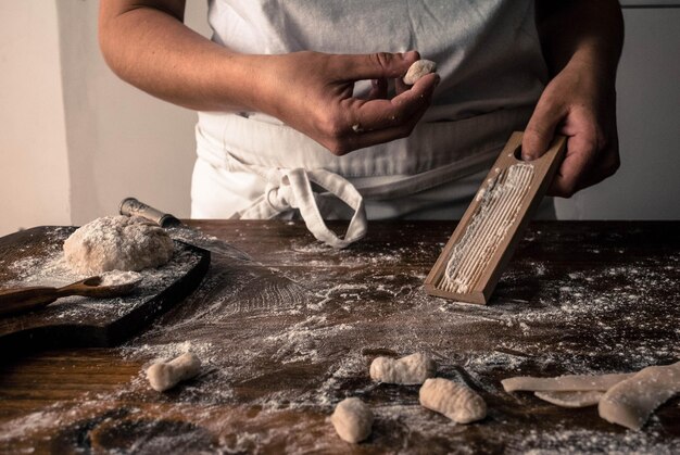 Foto una mujer está usando una cuchara de madera para cortar la masa.