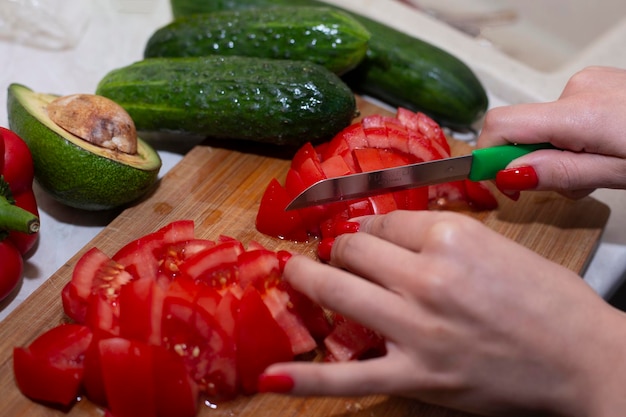 Una mujer usando un cuchillo afilado cortando tomates