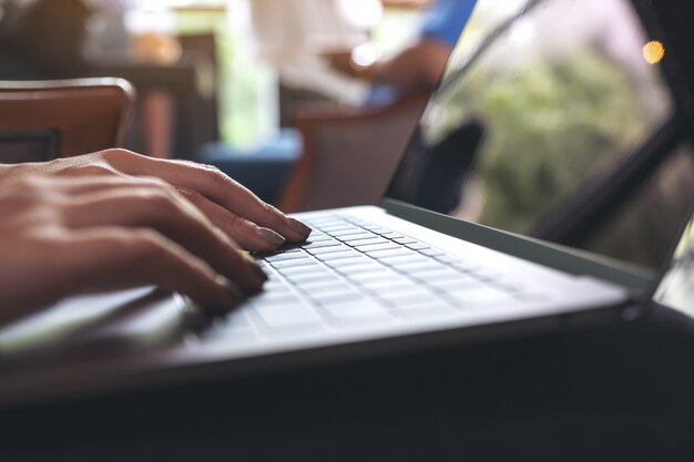 Mujer usando y escribiendo en la computadora portátil con pantalla de escritorio blanco en blanco