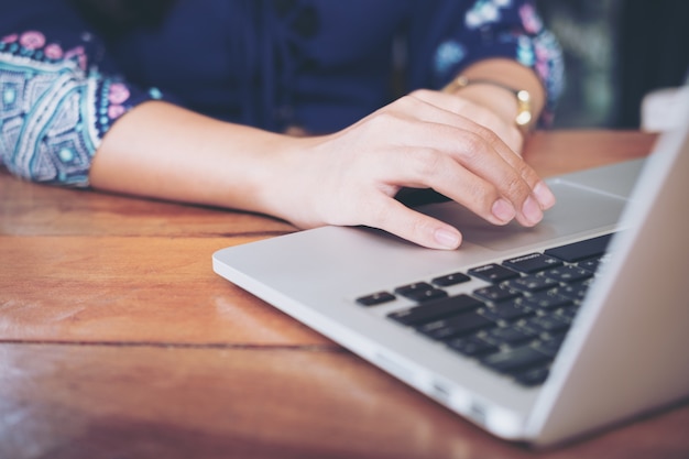 Foto mujer usando y escribiendo en el teclado de la computadora portátil