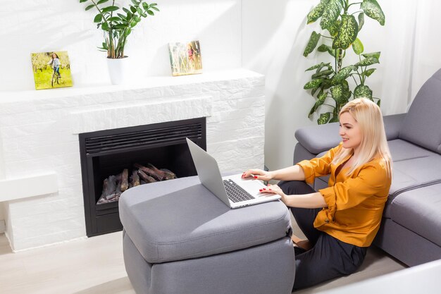 Mujer usando laptop y trabajando desde casa