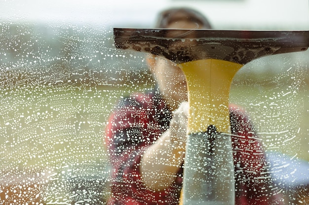 Mujer usando un limpiador de ventanas eléctrico