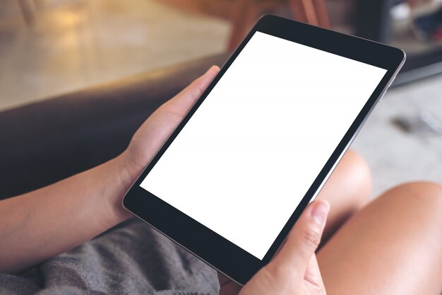 Mujer usando y mirando tableta con pantalla de escritorio blanco en blanco