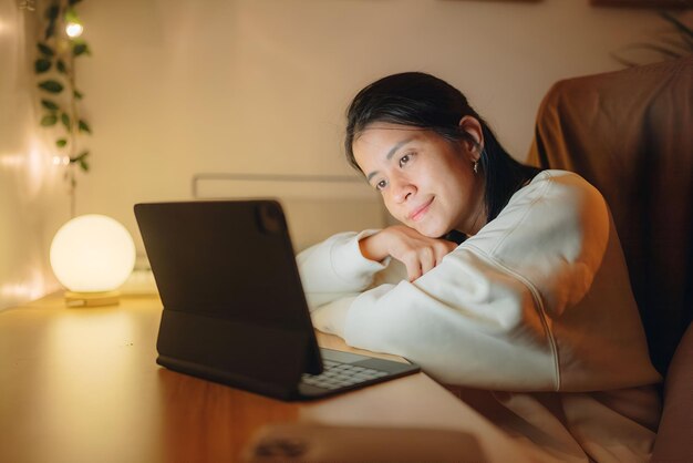 Mujer usando portátil por la noche mujer joven usando computadora en casa