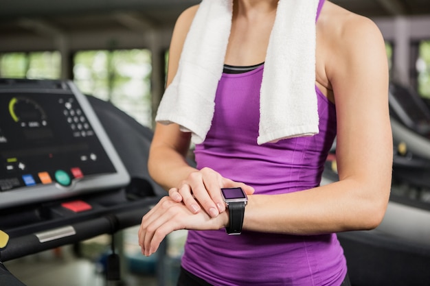 Foto mujer usando reloj inteligente en cinta de correr