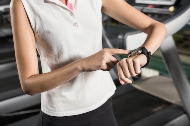 Mujer usando reloj inteligente en el gimnasio