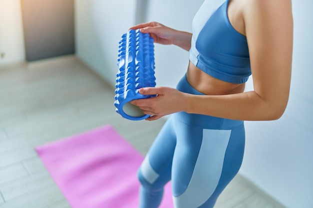 Mujer usando rodillo para calentar músculos