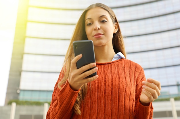 Mujer usando su teléfono inteligente al aire libre