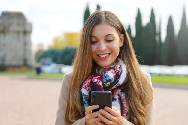 Mujer usando su teléfono mientras caminaba por la ciudad