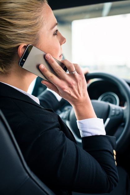 Mujer usando su teléfono mientras conduce el auto