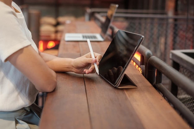 Mujer usando tableta para mensajes sms mano sosteniendo lápiz escribiendo teléfono móvil con pantalla táctil en café o tecnología de estilo de vida de oficina moderna Redes sociales y concepto de red