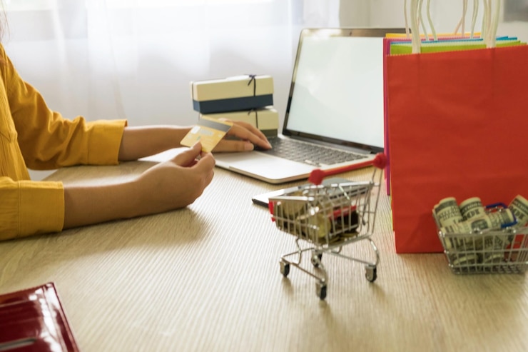 Foto mujer usando tarjeta de crédito y portátil para comprar en línea en casa