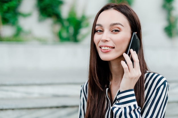 Mujer usando el teléfono al aire libre en la ciudad