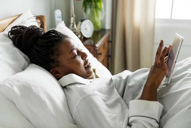 Una mujer usando un teléfono en la cama