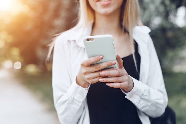 Mujer usando un teléfono inteligente en la calle