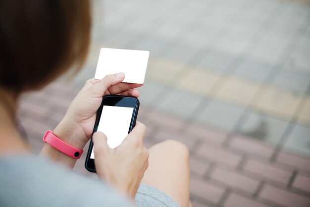 Mujer usando teléfono y tarjeta para ir de compras