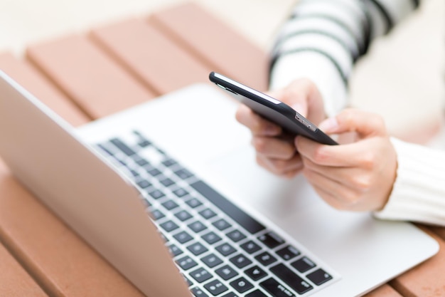 Mujer uso de computadora portátil y teléfono celular