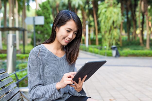 Mujer uso de tableta digital en el parque