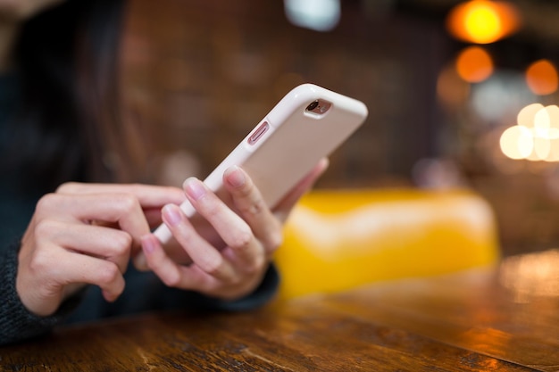 Mujer uso de teléfono móvil en la cafetería.