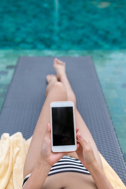 Foto mujer uso de teléfono móvil en piscina