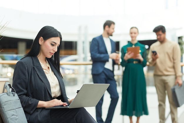 mujer, utilizar, computador portatil, en, edificio de oficinas