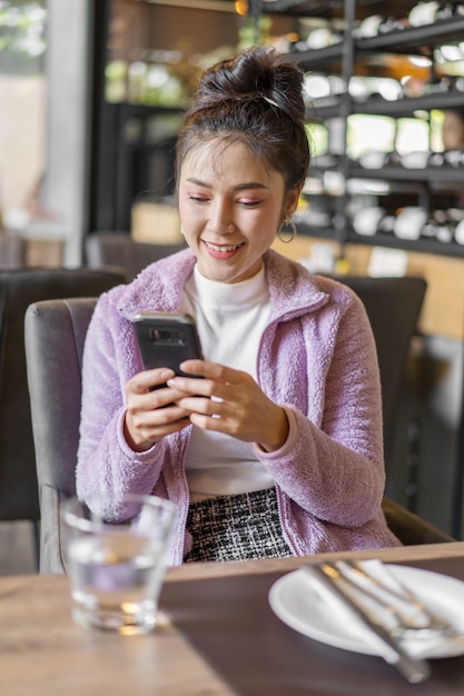 Mujer, utilizar, smartphone, en, restaurante