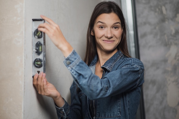 Mujer utilizó la medición de la regla de equilibrio de la desviación vertical de la regla de nivel de burbuja de construcción ...