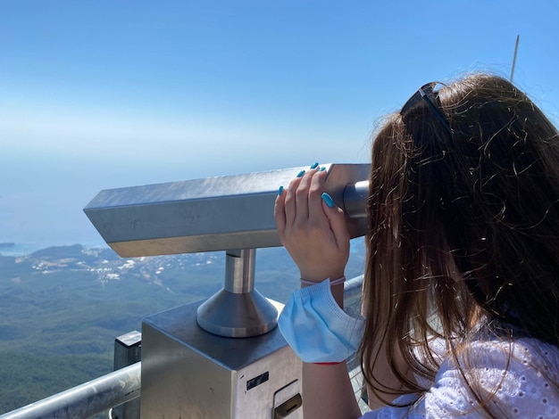 Mujer de vacaciones mirando a través de binoculares