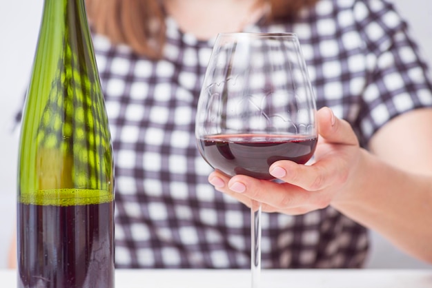 Una mujer con un vaso de vino rojo una mujer está bebiendo vino rojo