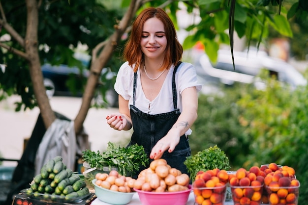 Mujer vendedora en el mostrador con verduras Concepto de pequeña empresa