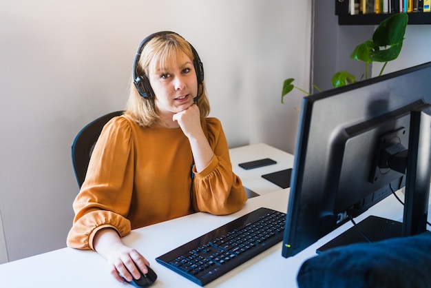 Mujer vendedora telefónica trabajando mirando su computadora en la oficina