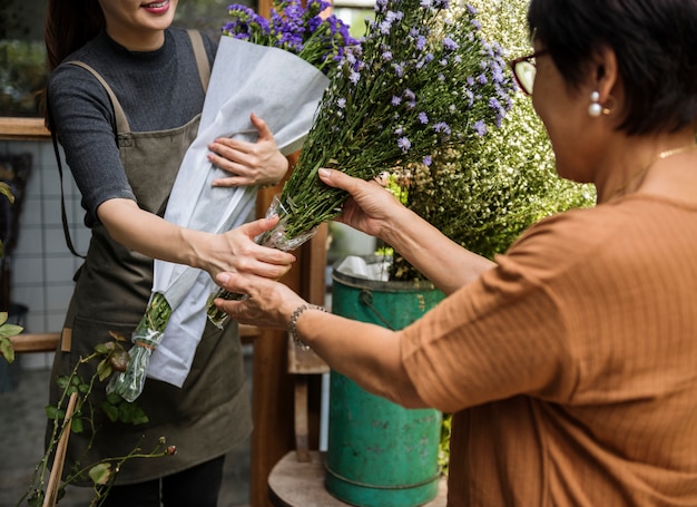 Mujer vendiendo flores a su cliente