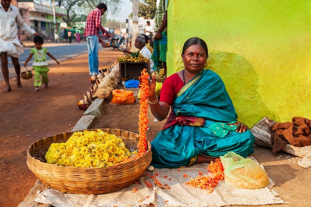 Mujer vendiendo ofrendas florales de puja