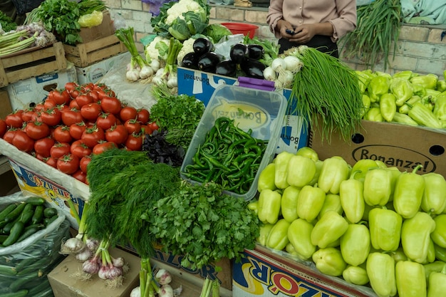 Una mujer vendiendo todas las verduras.