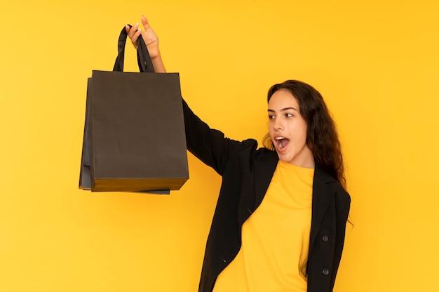 Mujer de ventas con bolsa de papel negro.