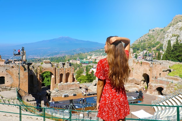 Mujer ver ruinas del teatro griego en Taormina con el volcán Etna, Sicilia