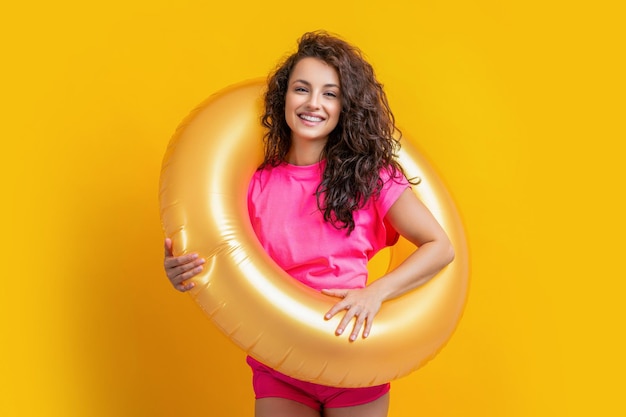 Mujer de verano feliz con anillo inflable aislado en mujer de verano amarillo