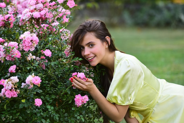 Foto mujer de verano en el jardín de rosas al aire libre. chica de belleza natural disfruta de la recreación de primavera.
